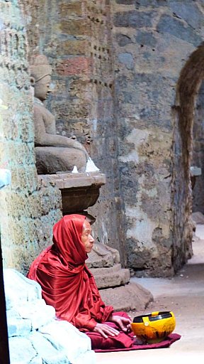 And&auml;chtig betender M&ouml;nch vor eine der vielen Buddha-Statuen - West-Myanmar: Sehensw&uuml;rdigkeiten