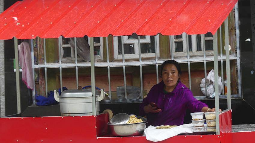 Tibeterin mit Stra&szlig;enstand - S&uuml;d-Ost-Tibet: Essen & Schlafen